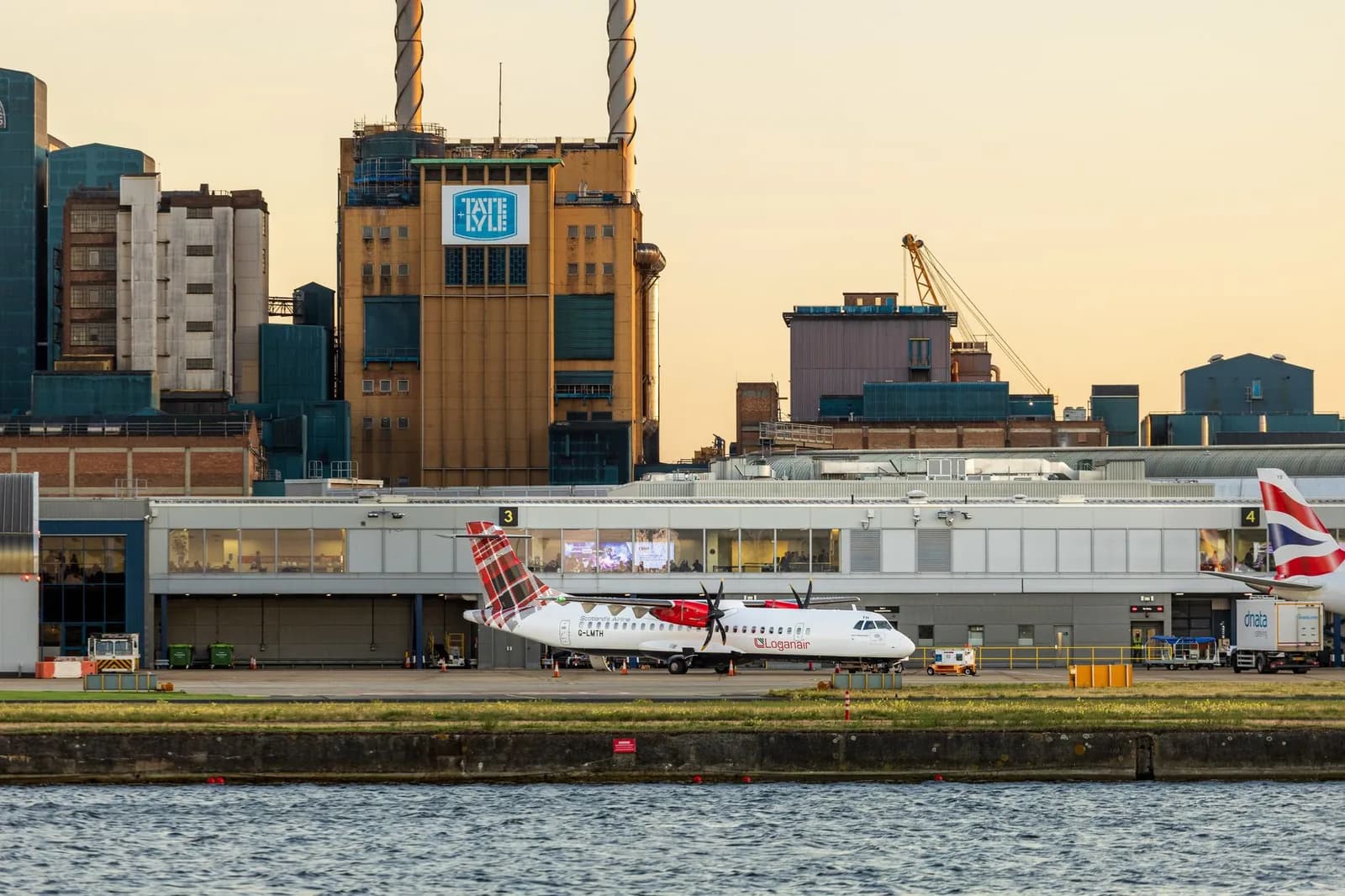 Terminal et piste d'un aéroport de Londres, avec des avions de ligne au sol