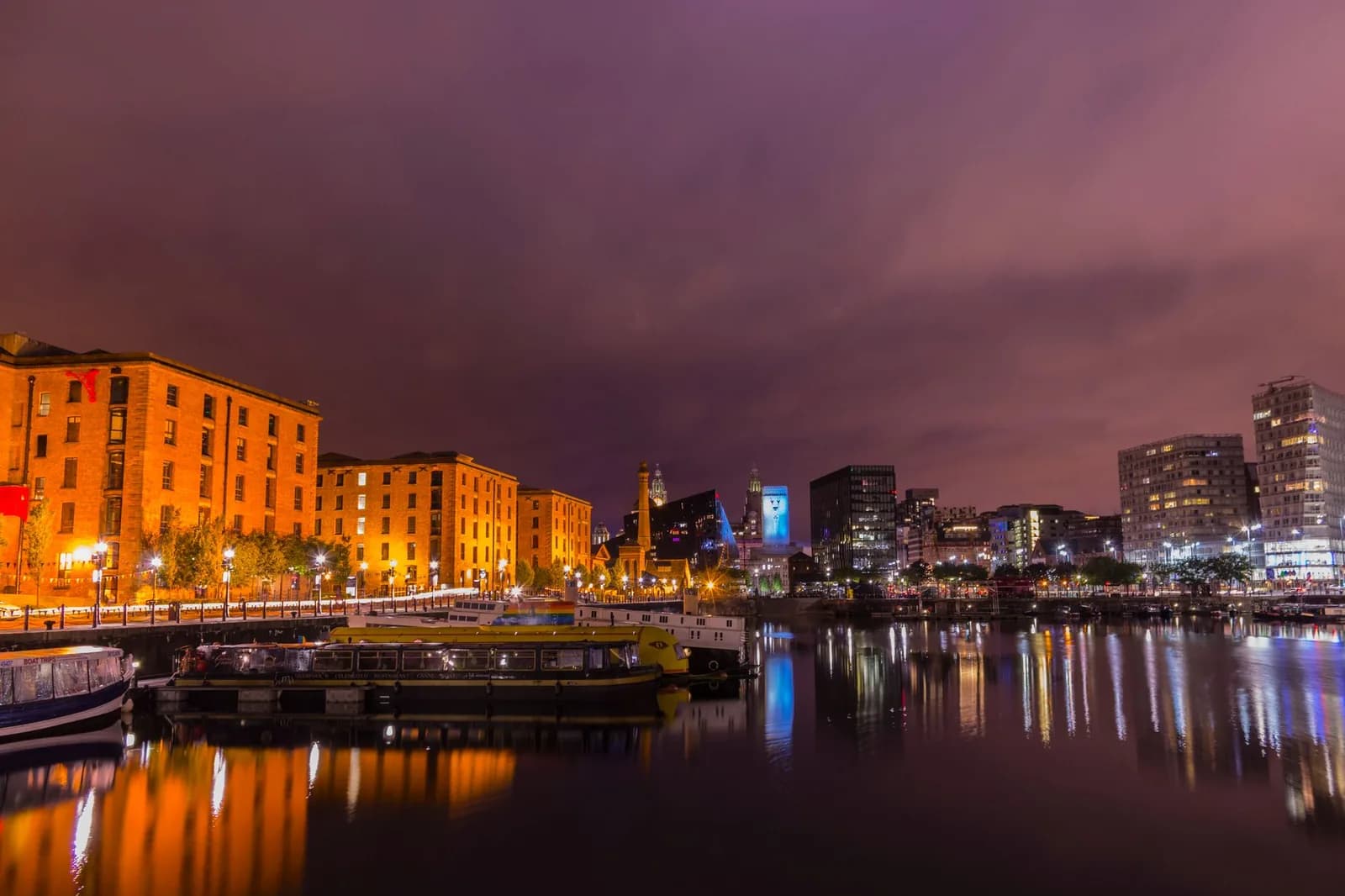 Les entrepôts du Royal Albert Dock de Liverpool éclairés la nuit, reflétés dans le bassin