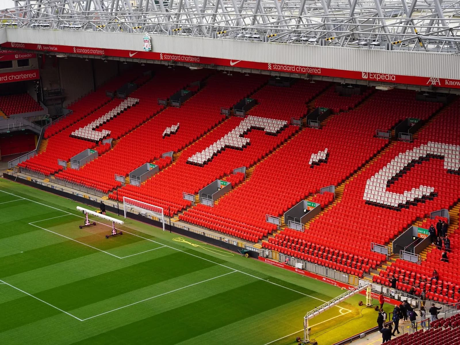 Une tribune rouge d'Anfield avec les lettres LFC dessinées dans les sièges, face à la pelouse
