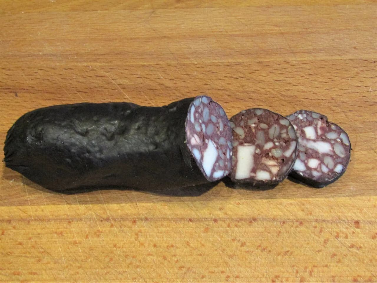 Black pudding coupé en tranches, où l'on voit le sang, les morceaux de gras et les céréales