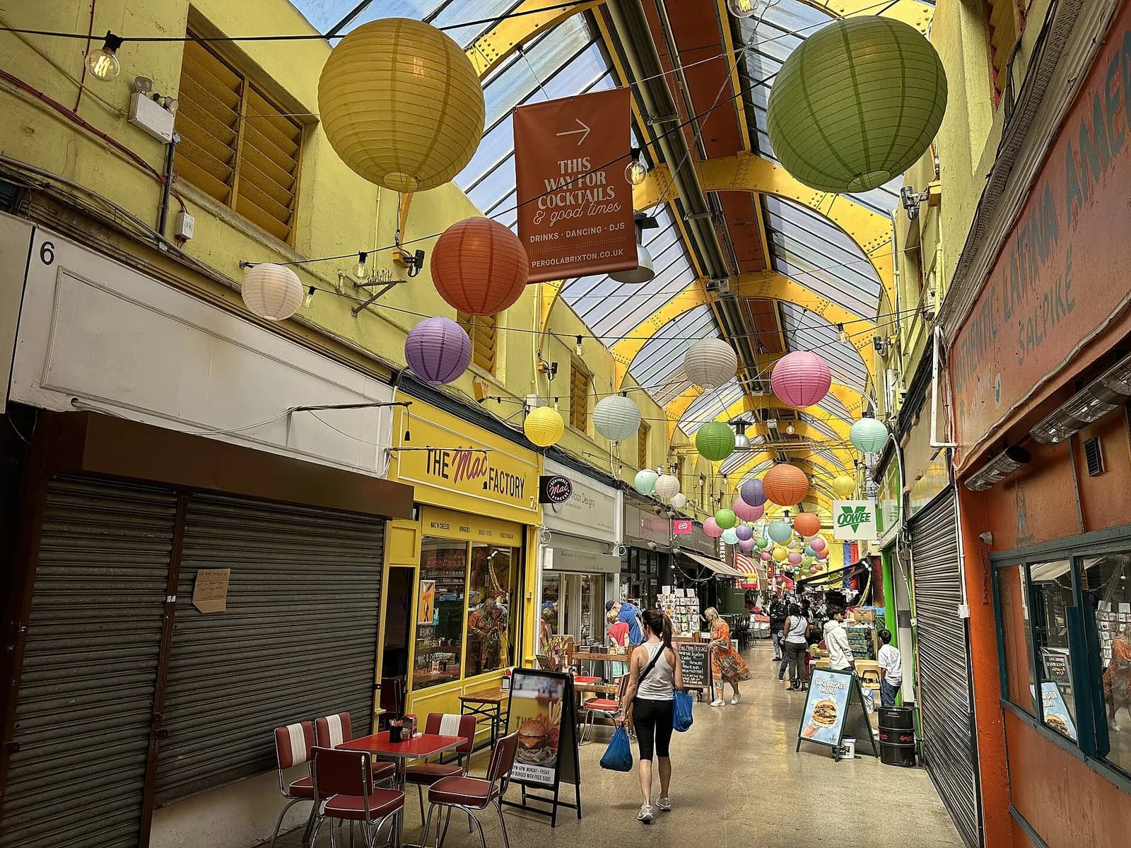 Galerie couverte de Brixton Village avec ses lanternes suspendues, ses boutiques et ses restaurants