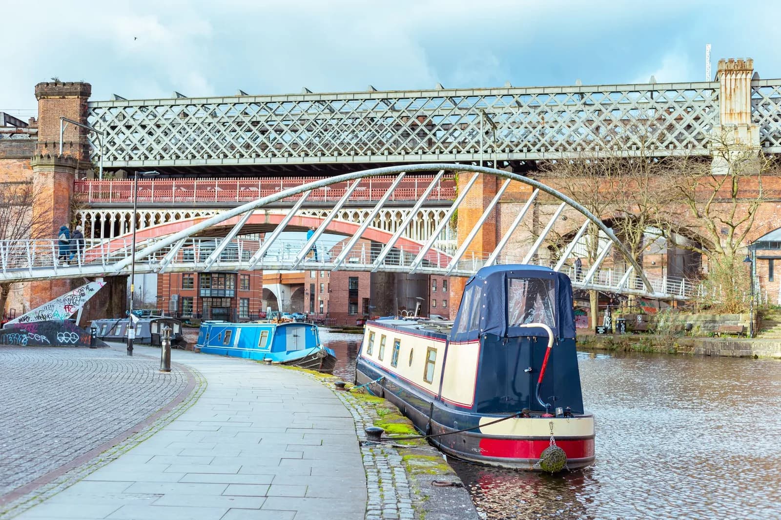 Bassin de canal et viaducs ferroviaires métalliques de Castlefield à Manchester, avec des péniches