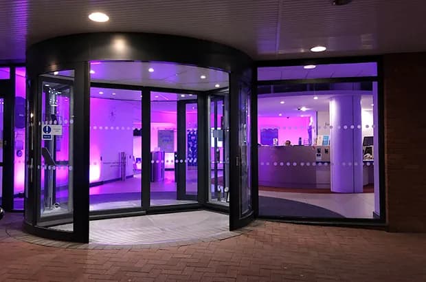Entrée du siège de Companies House à Cardiff, éclairée en violet le soir