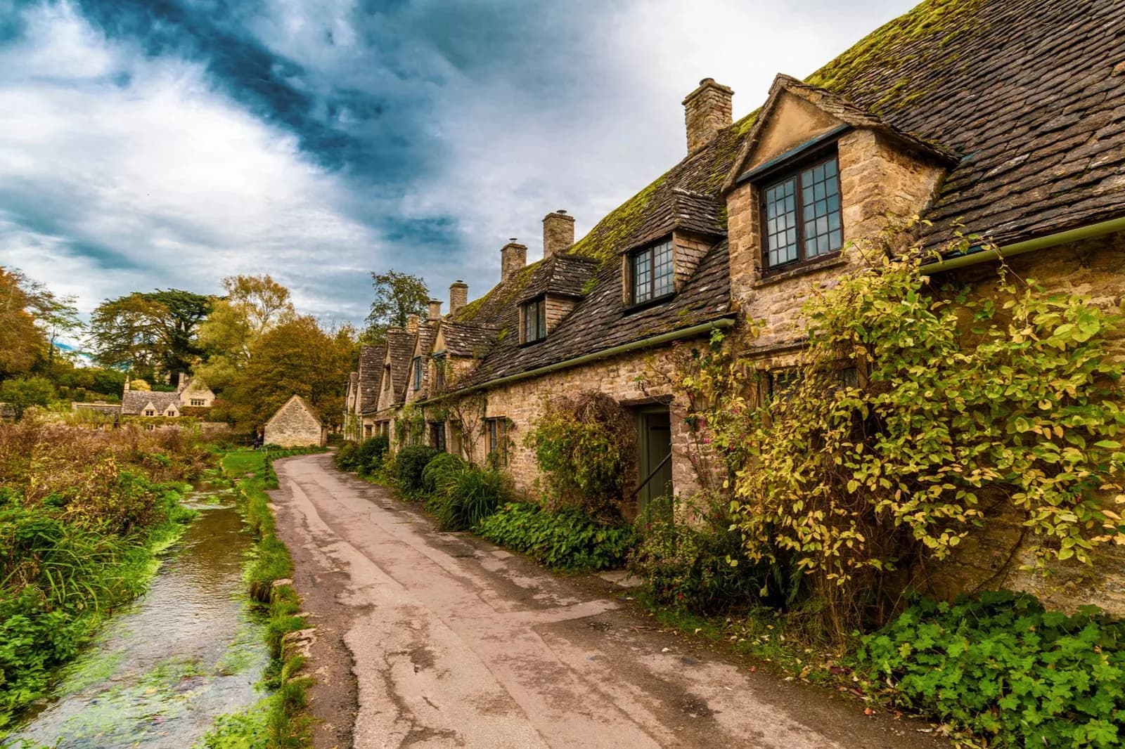 Cottages en pierre le long d'un chemin et d'un ruisseau à Bibury, dans le Gloucestershire