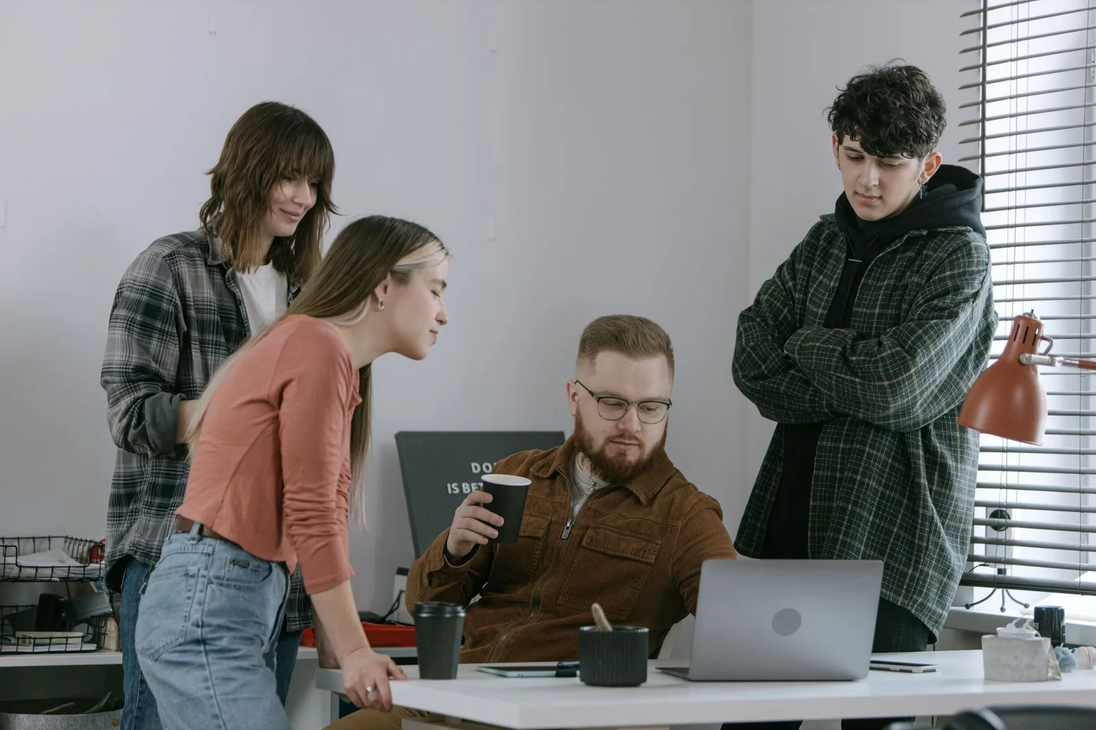 Équipe réunie autour d'un ordinateur portable dans un bureau de jeune entreprise
