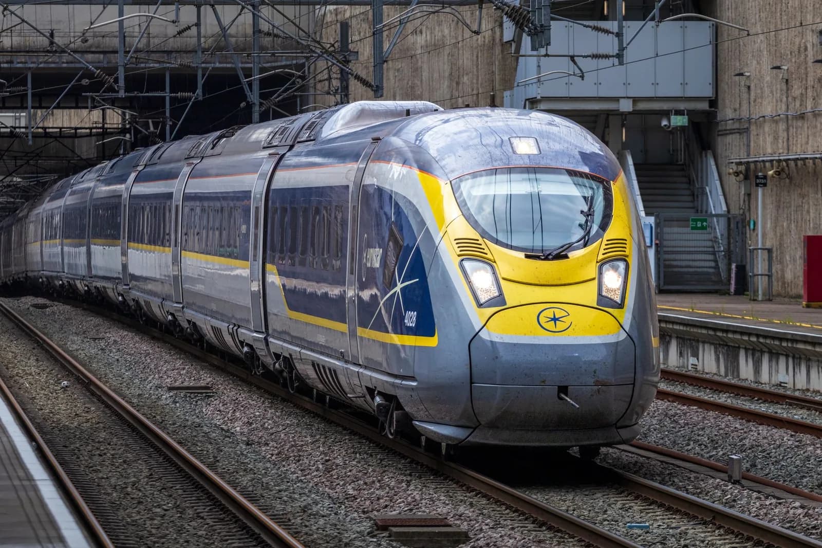 Train Eurostar bleu et jaune entrant en gare, l'autre train qui emprunte le tunnel sous la Manche