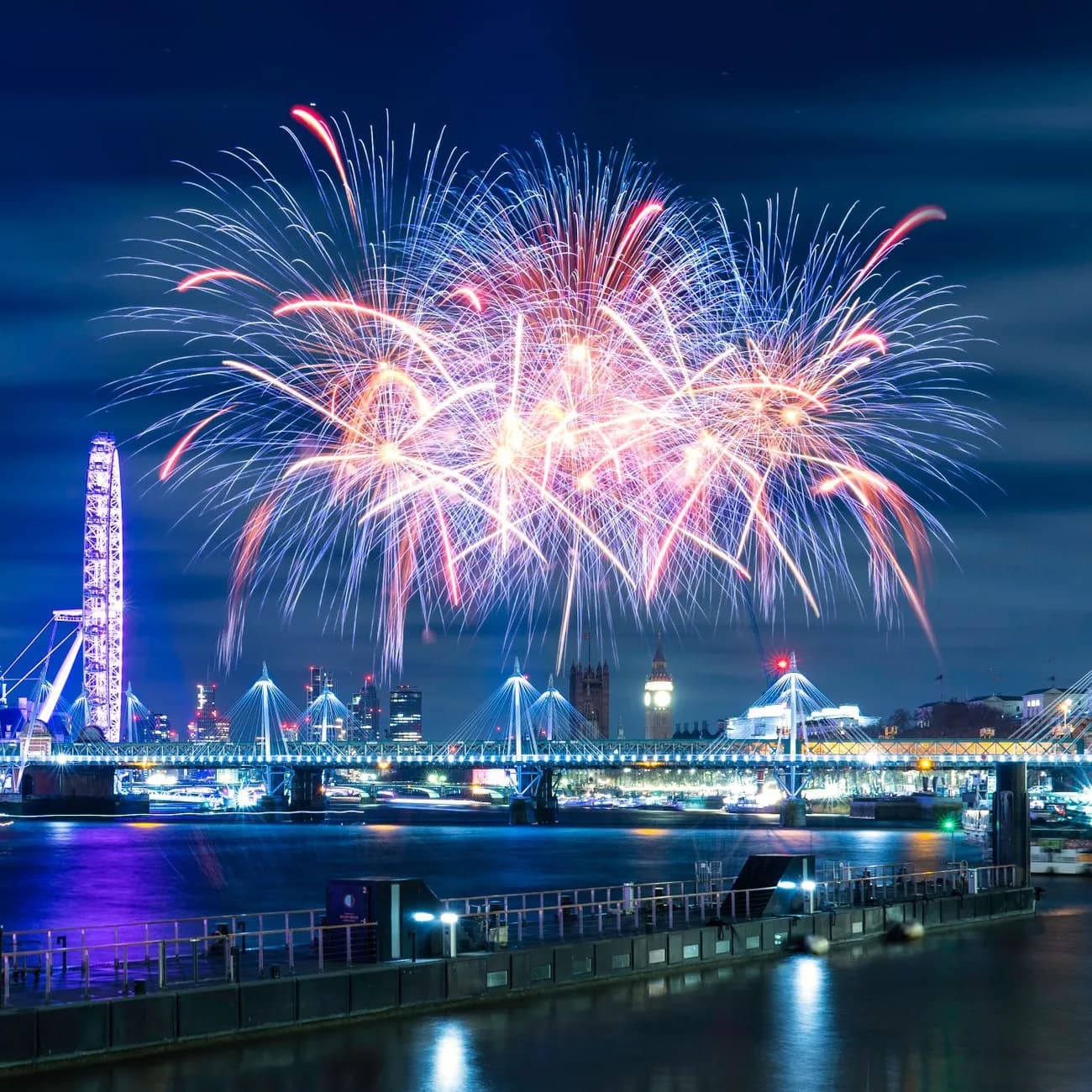 Feu d'artifice du Nouvel An au-dessus de la Tamise, avec le London Eye et le pont de Hungerford illuminés, Londres