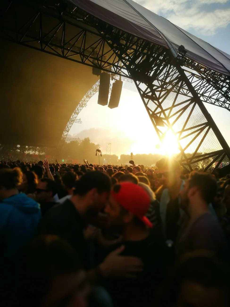 Foule devant la scène d'un festival de musique en plein air au coucher du soleil