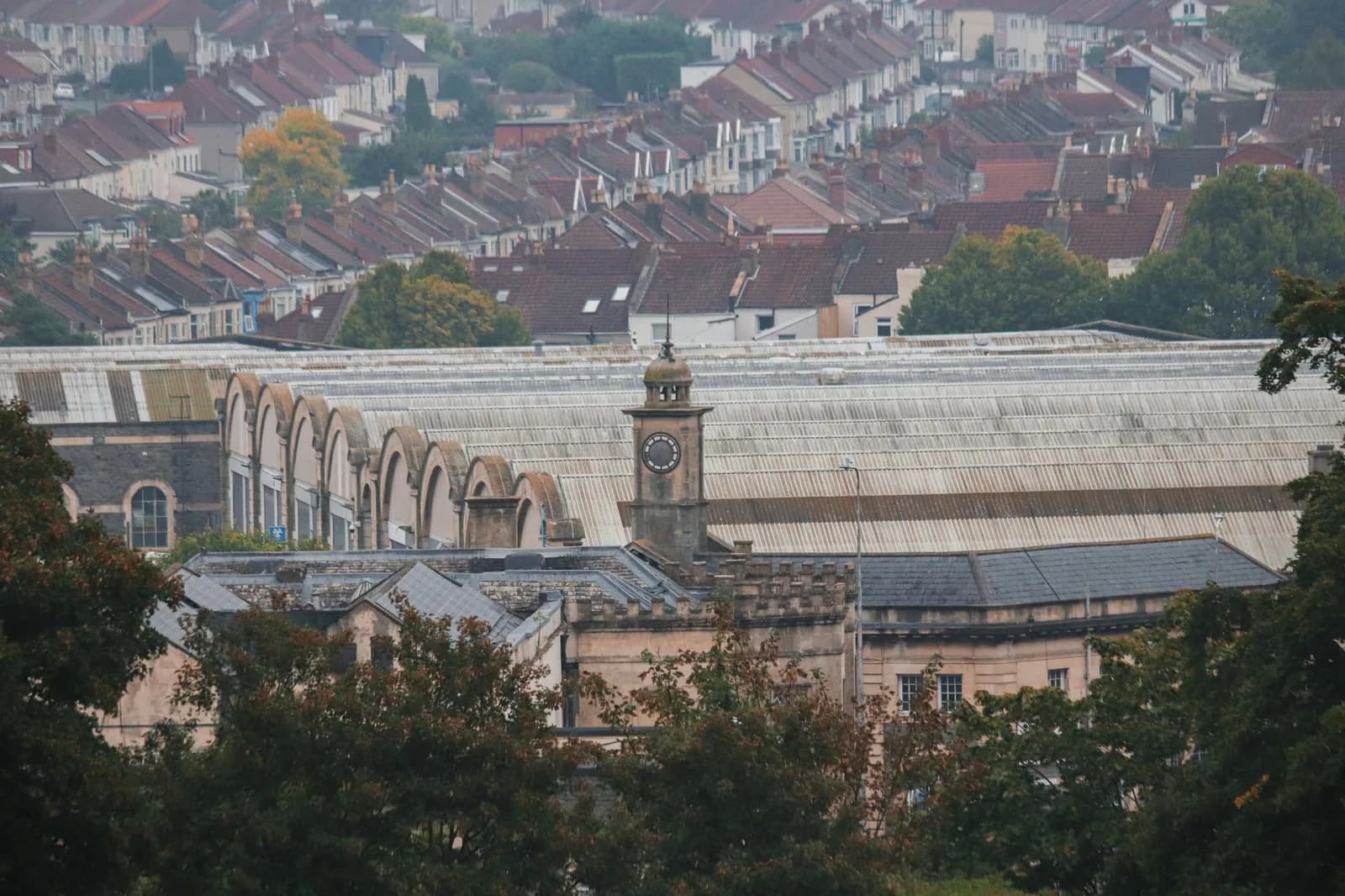 Toit de la halle victorienne et tour de l'horloge de la gare de Bristol Temple Meads, vus au-dessus des toits