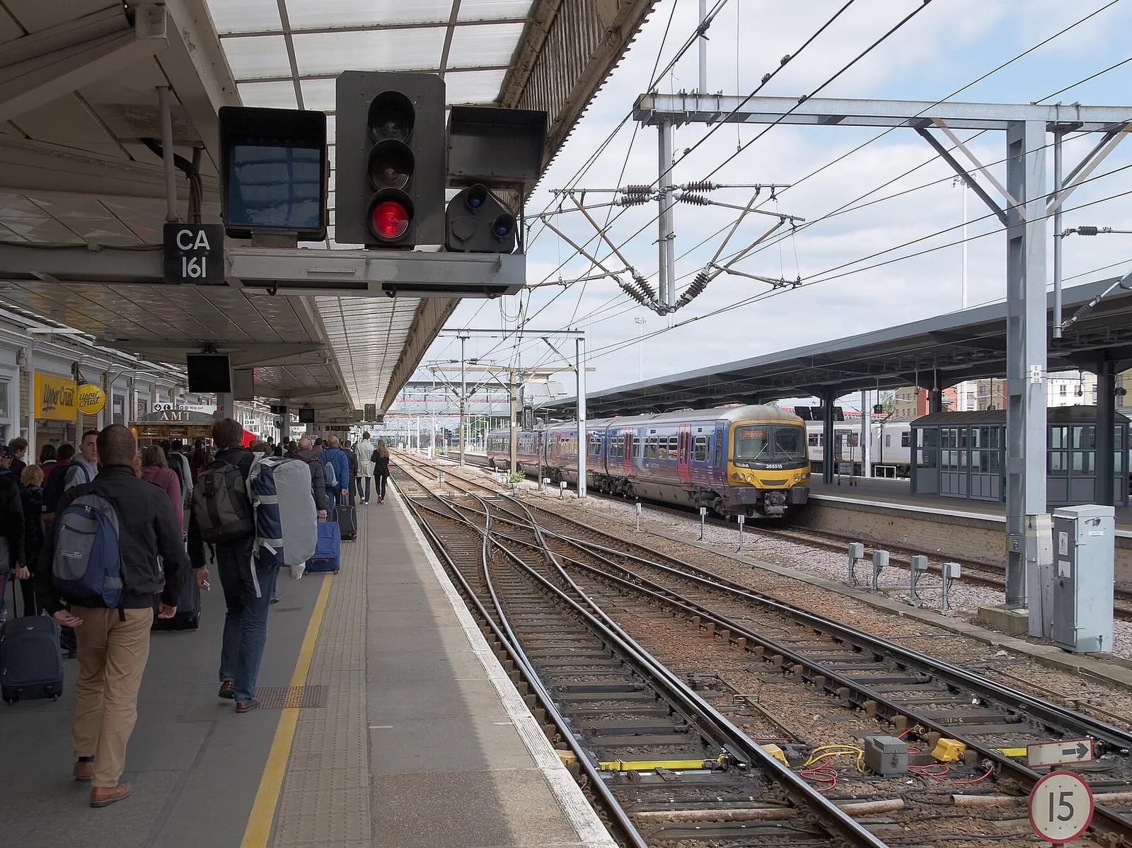 Quai de la gare de Cambridge, avec des voyageurs et un train à l'arrêt