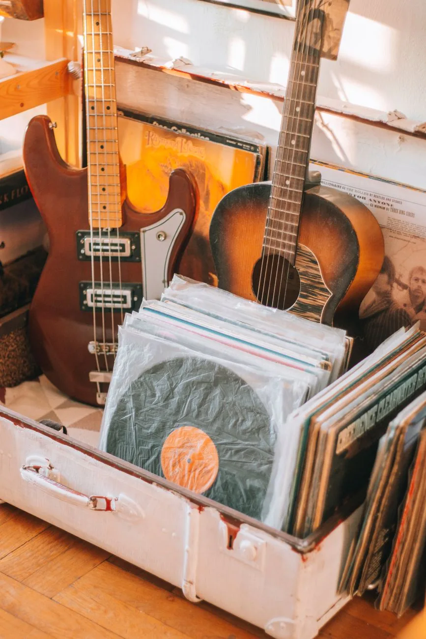 Guitares appuyées contre un mur et caisse de disques vinyle