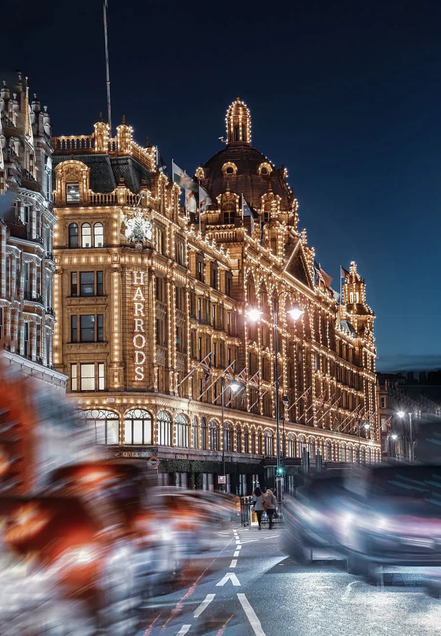 La façade de Harrods éclairée par ses ampoules à la nuit tombée