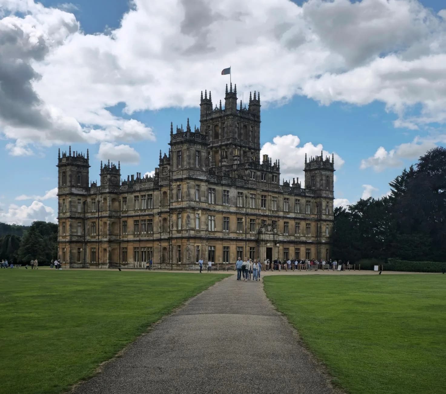 La façade victorienne de Highclere Castle dans le Hampshire, avec sa tour centrale et sa pelouse