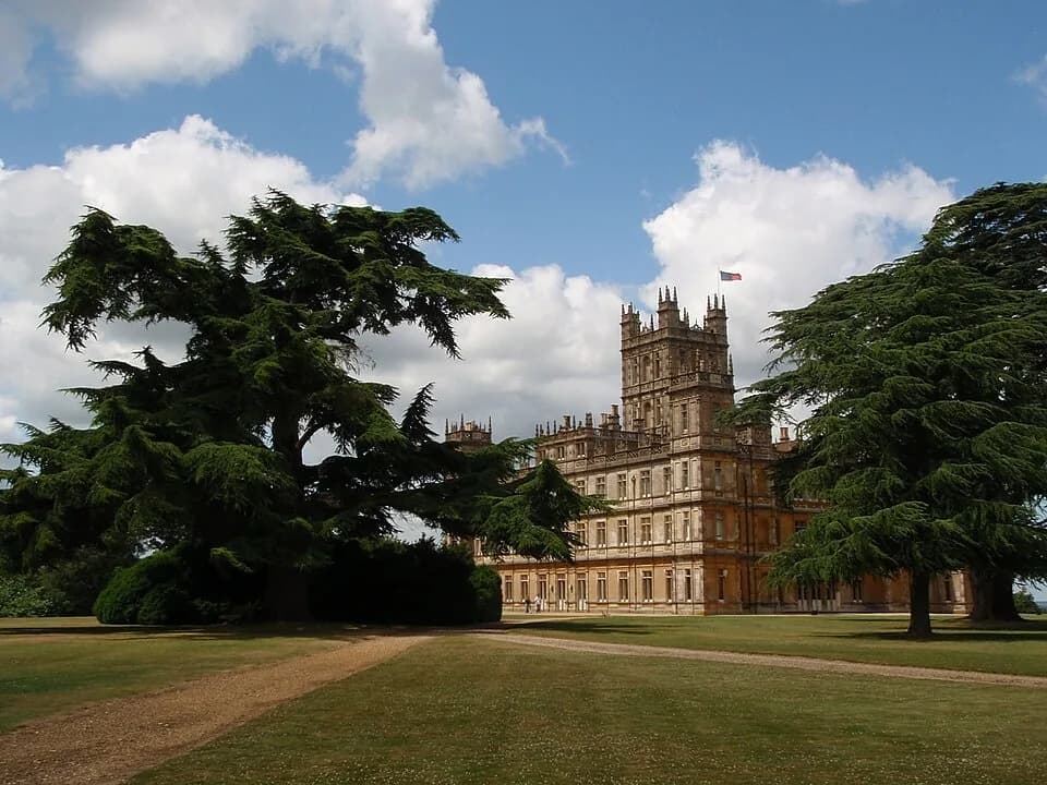 Highclere Castle vu de loin à travers les cèdres du parc paysager, dans le Hampshire