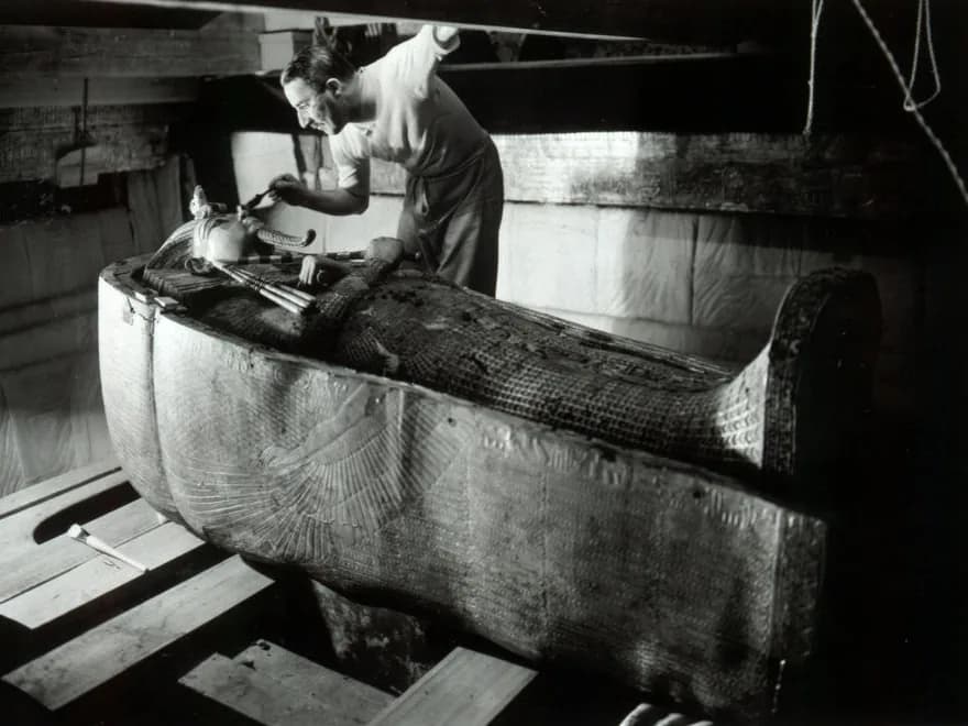 Howard Carter au travail près d'un sarcophage dans la tombe de Toutânkhamon, photographie de Harry Burton