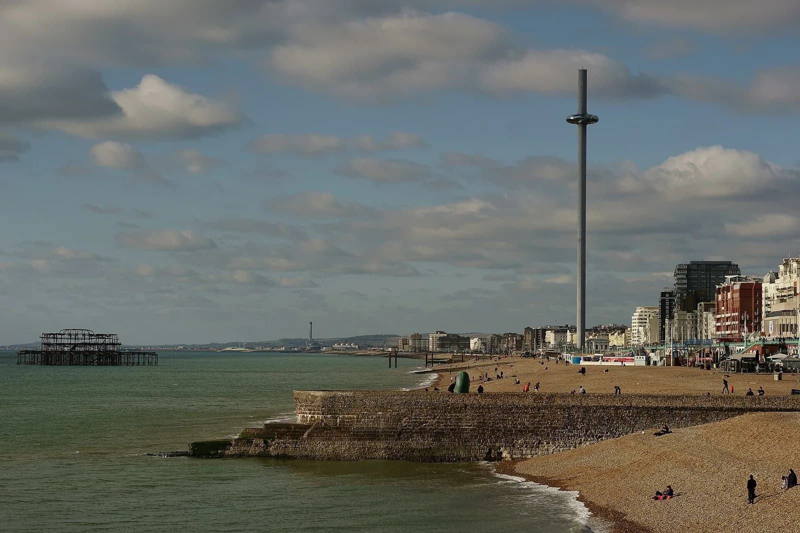 La tour i360 sur le front de mer de Brighton, avec la plage de galets et les restes du West Pier au large