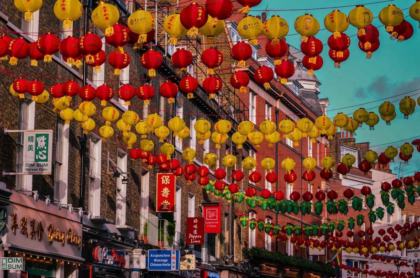 Lanternes rouges, jaunes et vertes suspendues au-dessus d'une rue de Chinatown, à Londres