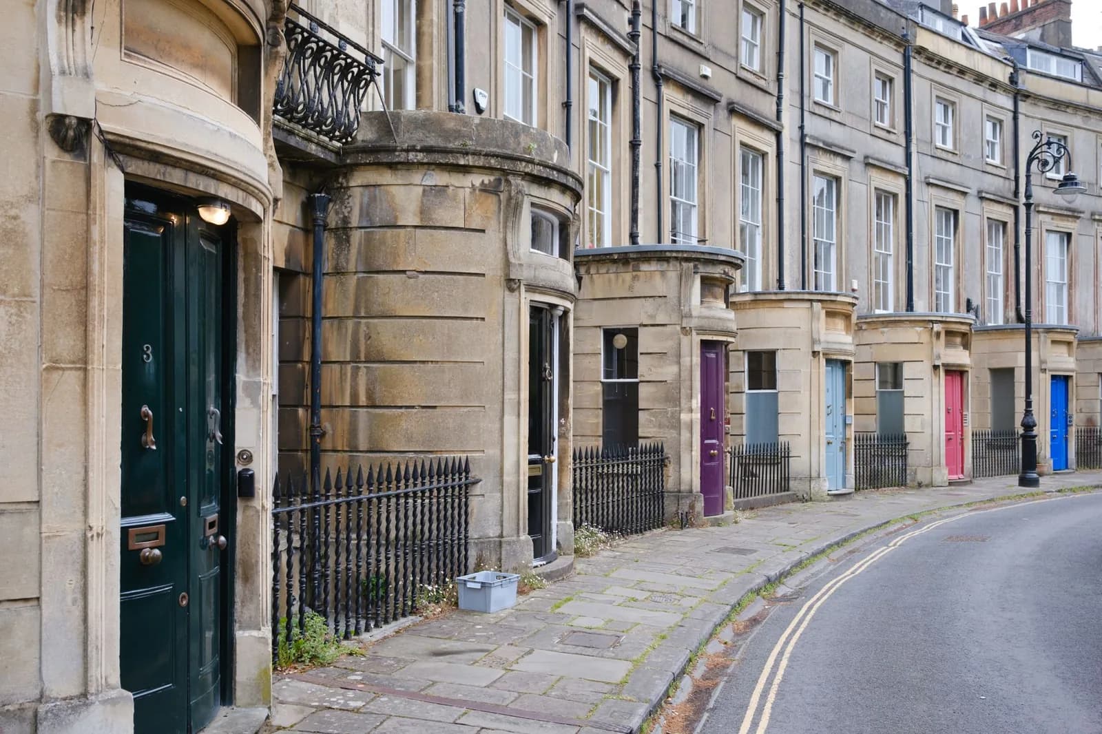 Alignement de maisons géorgiennes en pierre de Bath, avec portes colorées et grilles en fer