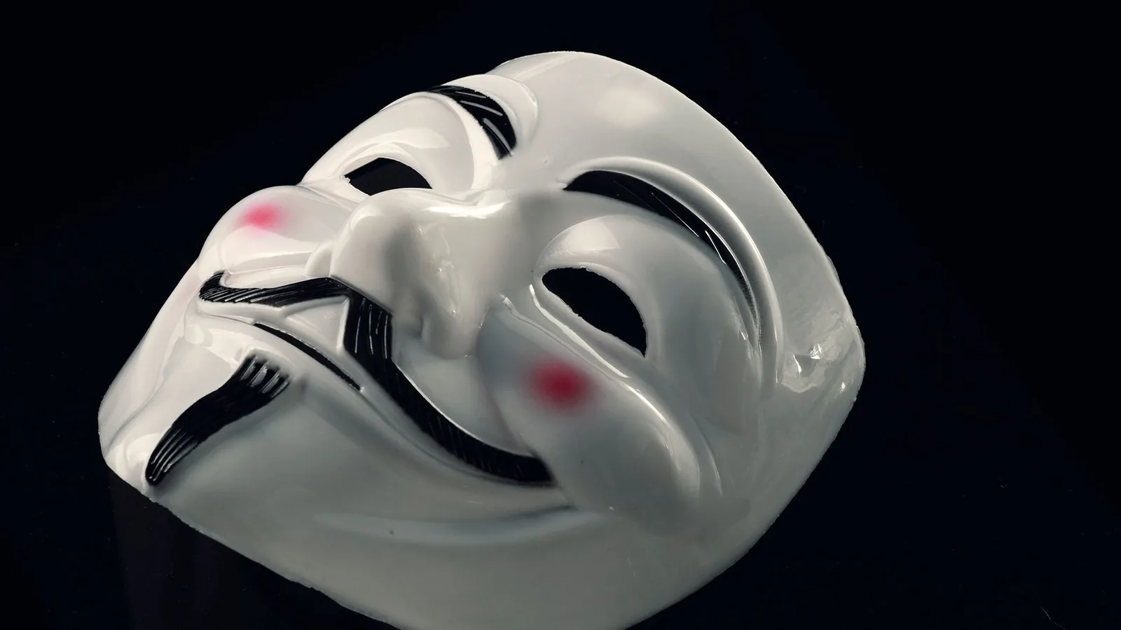 Masque blanc de Guy Fawkes à moustache et barbiche, sur fond noir