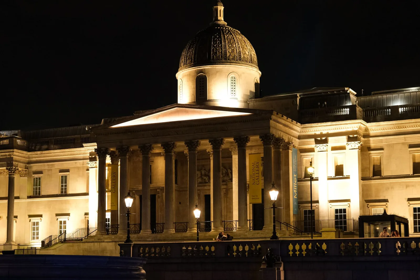 Le portique à colonnes de la National Gallery, illuminé la nuit, vu depuis Trafalgar Square