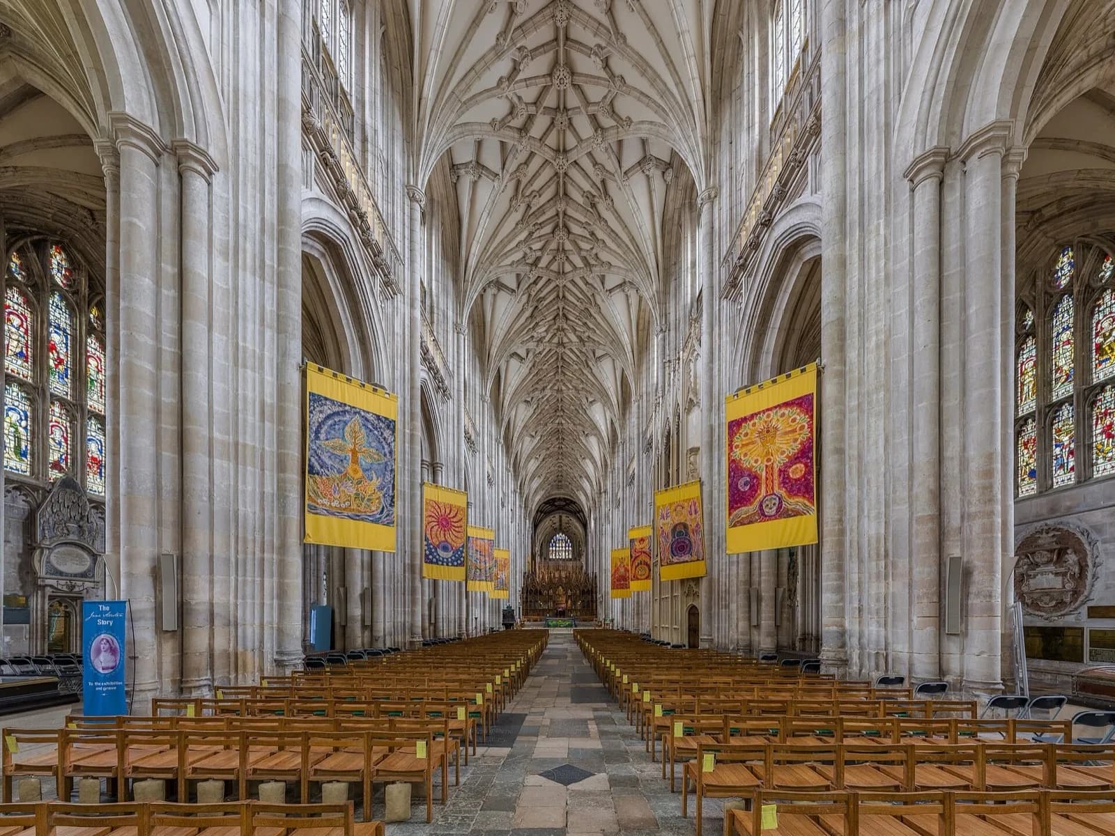 La nef de la cathédrale de Winchester, ses voûtes et ses bannières