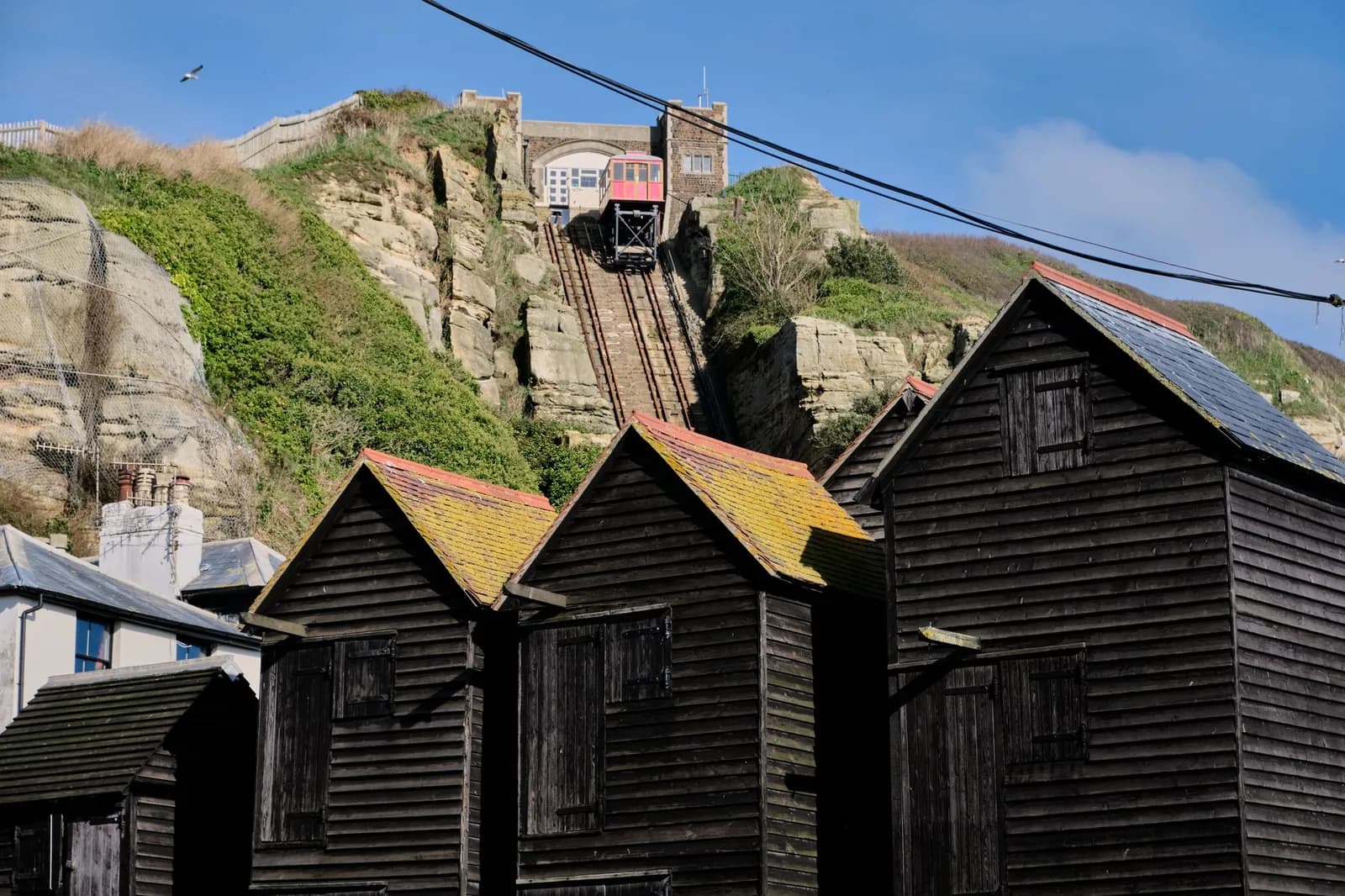 Les cabanes à filets noires de Hastings devant la falaise et son funiculaire