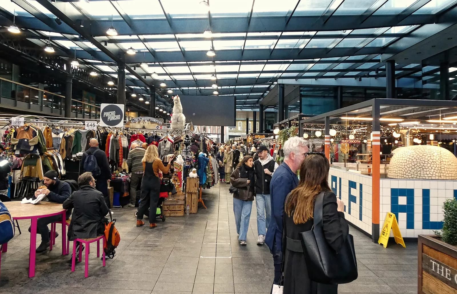 Étals et visiteurs sous la grande verrière d'Old Spitalfields Market, à l'est de la City