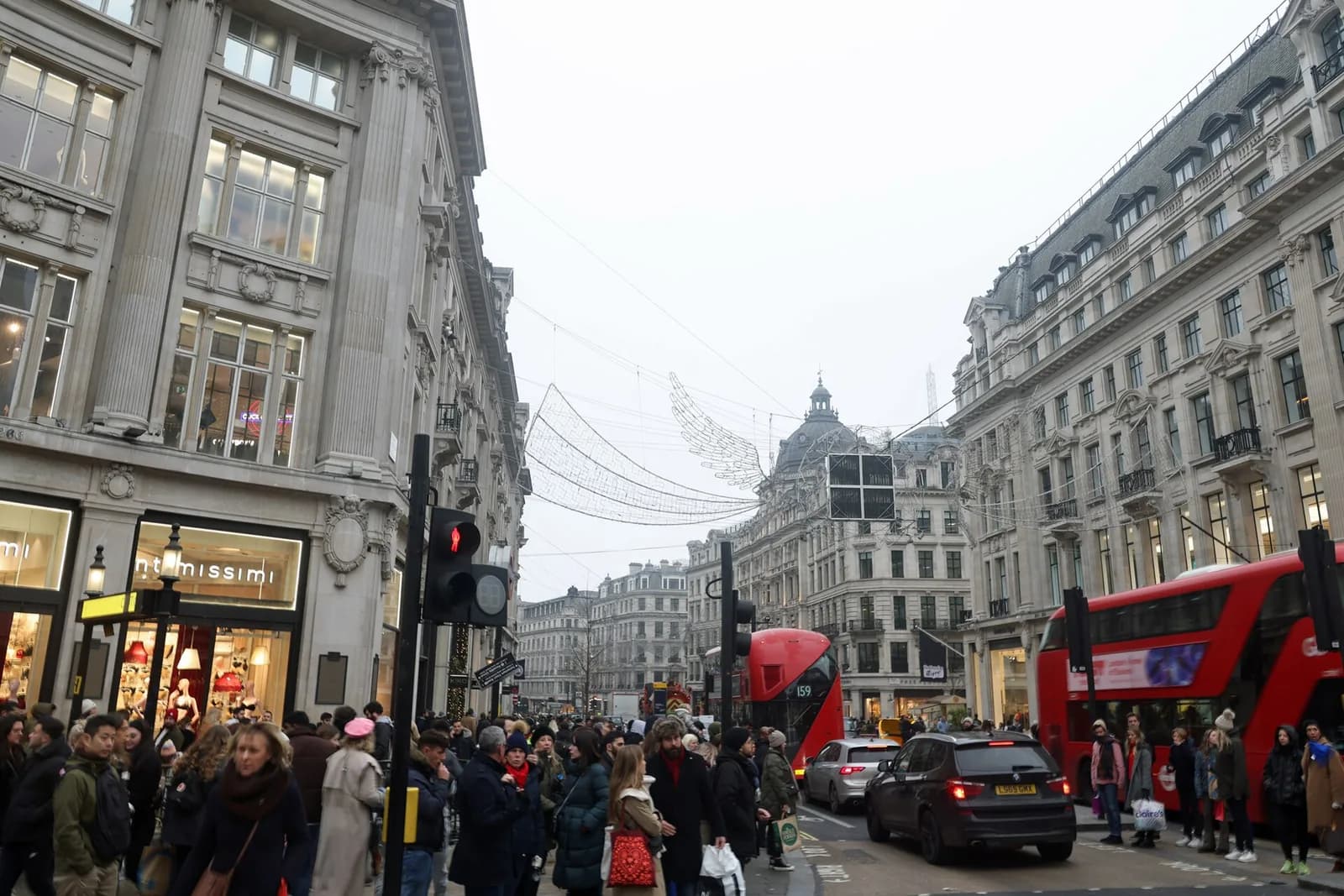 Foule de piétons et bus à impériale rouges sur Oxford Street à Londres, sous les décorations de Noël