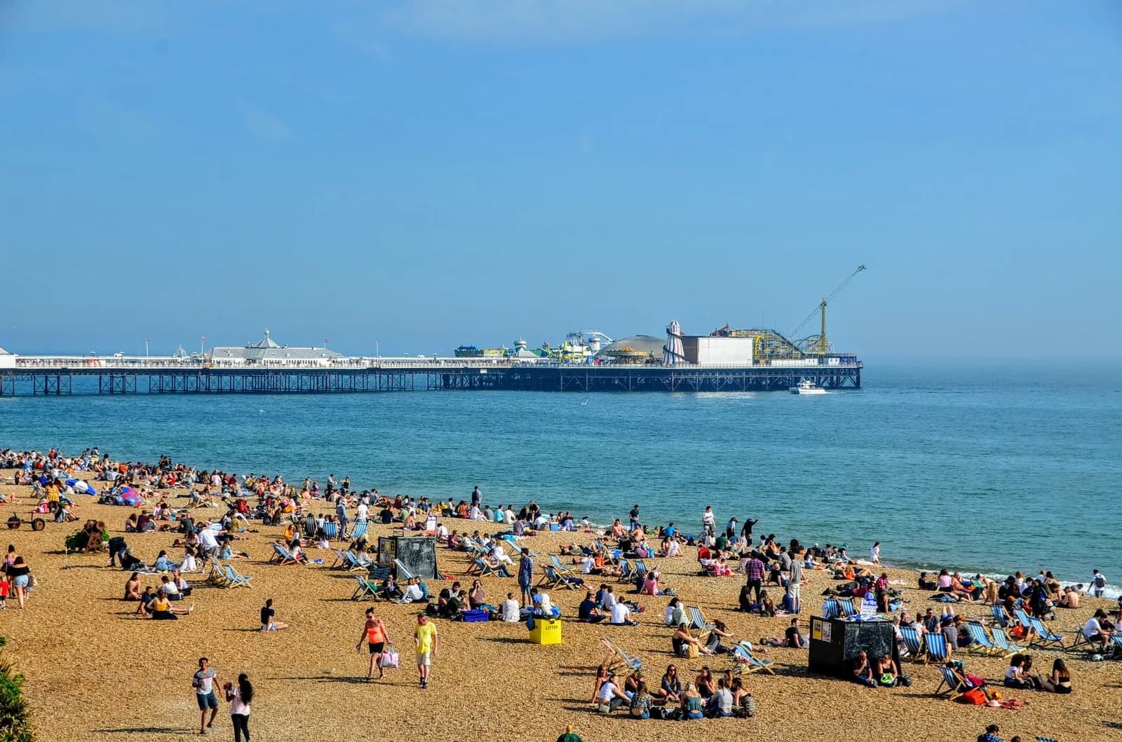 La plage de galets de Brighton couverte de transats, avec la jetée au fond