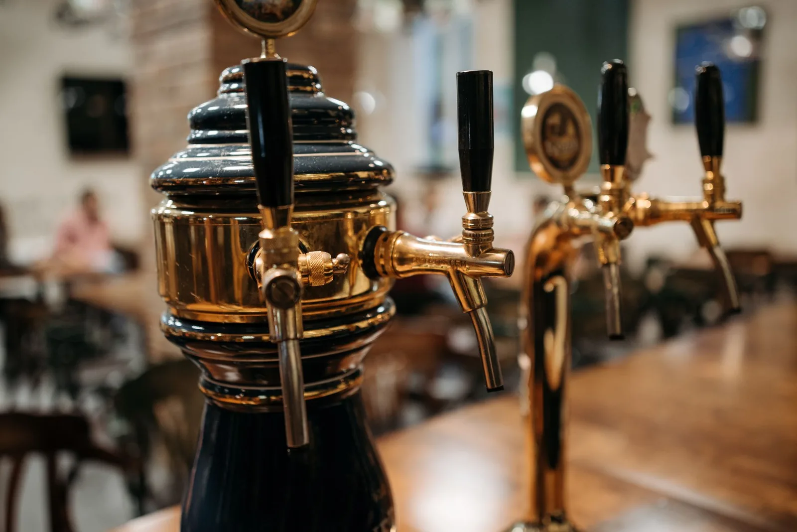 Pompes à bière en laiton sur le comptoir d'un pub