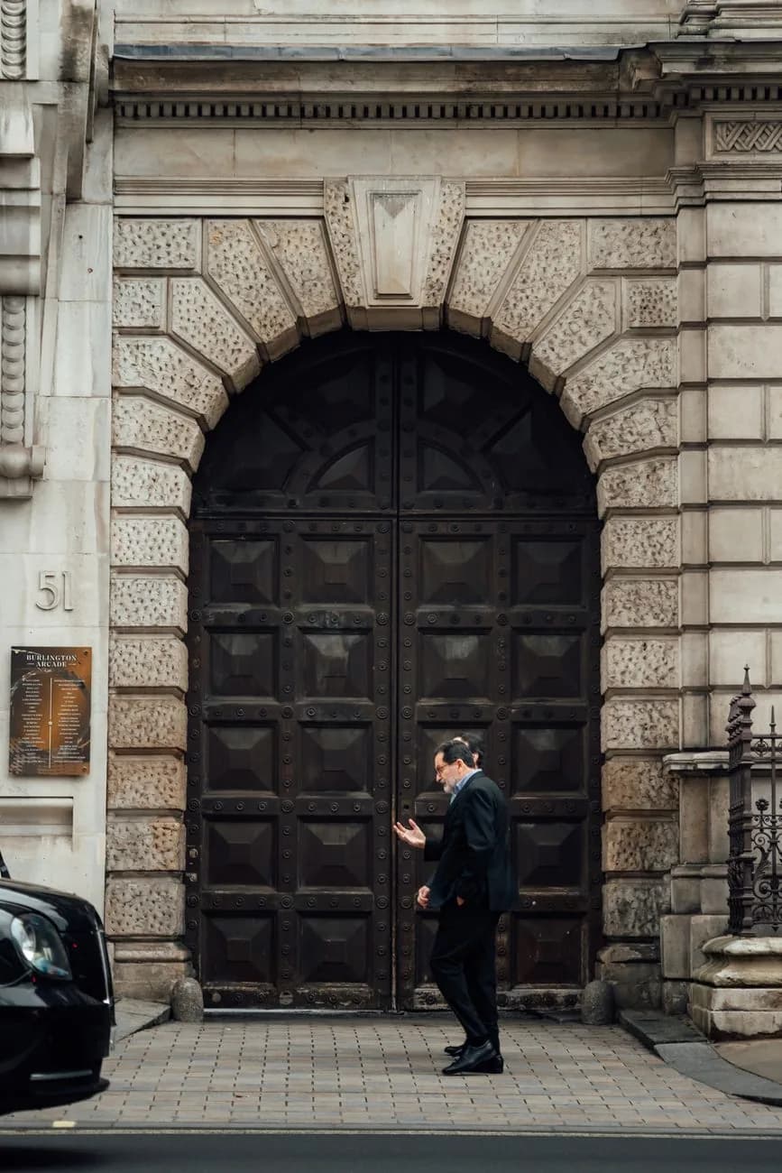 Une personne en costume passe devant une porte close, dans le quartier d'affaires de Londres