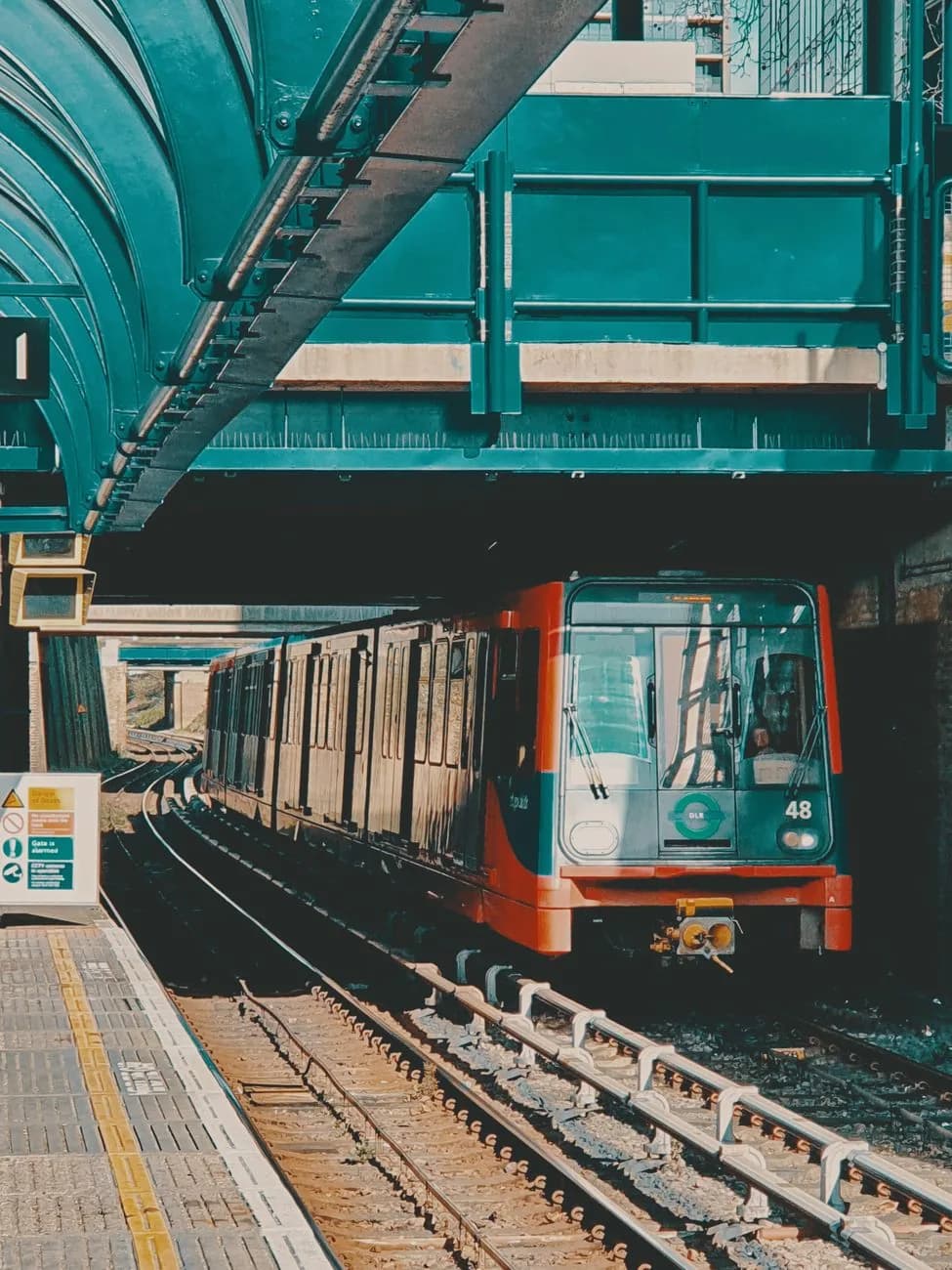Rame du DLR entrant en station sur un quai londonien