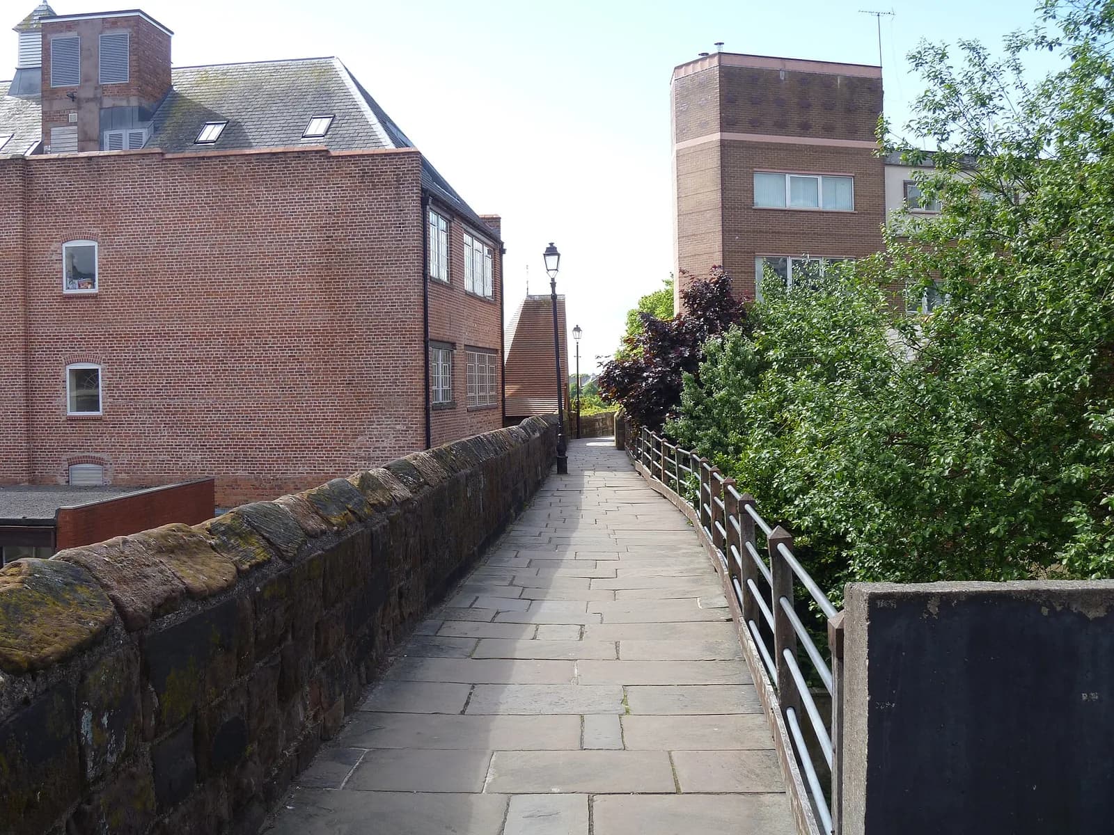 Le chemin de ronde pavé sur les remparts de Chester, entre le mur de grès rouge et les immeubles de brique