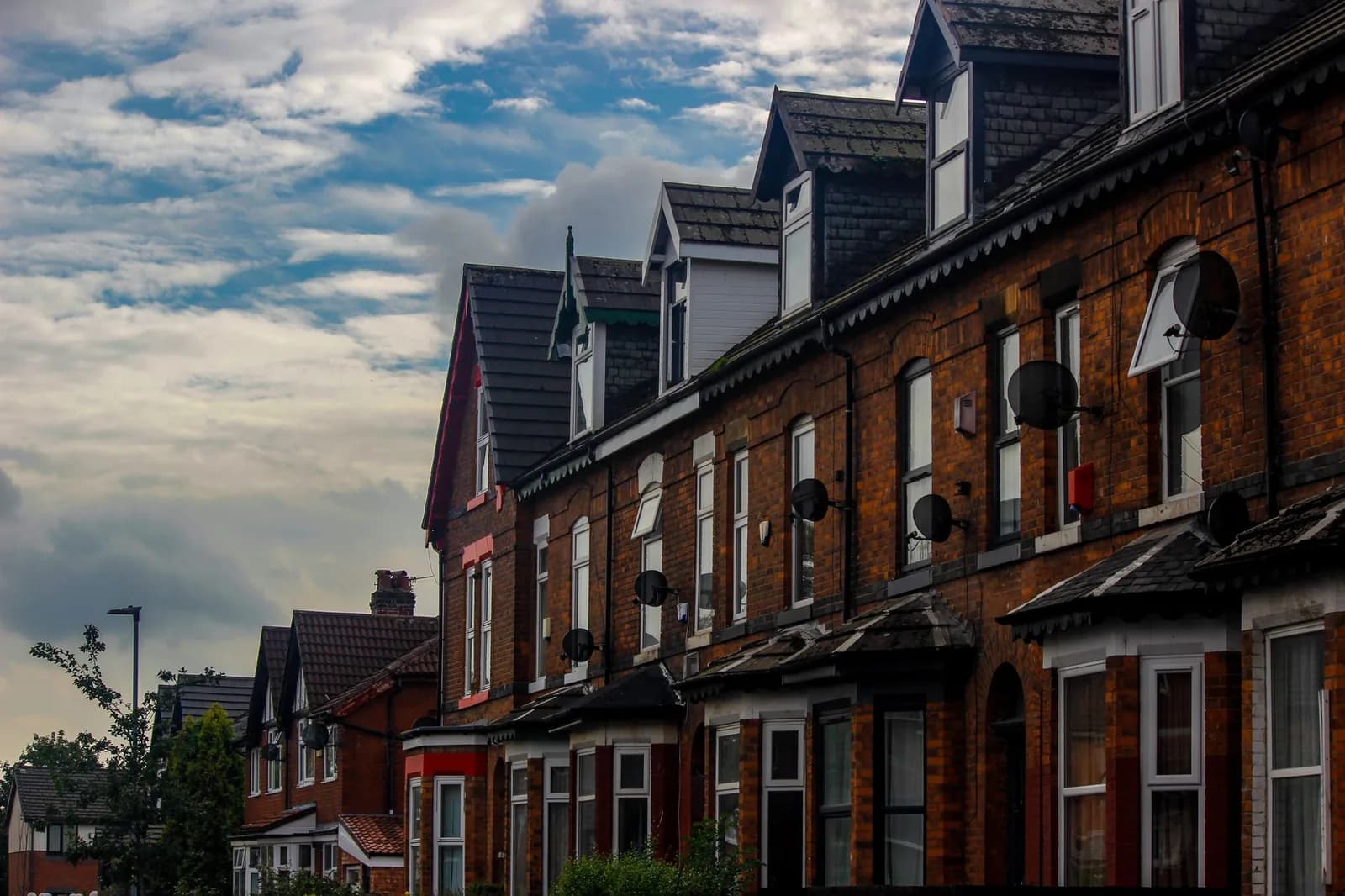 Rangée de maisons victoriennes en briques rouges dans un quartier résidentiel de Manchester