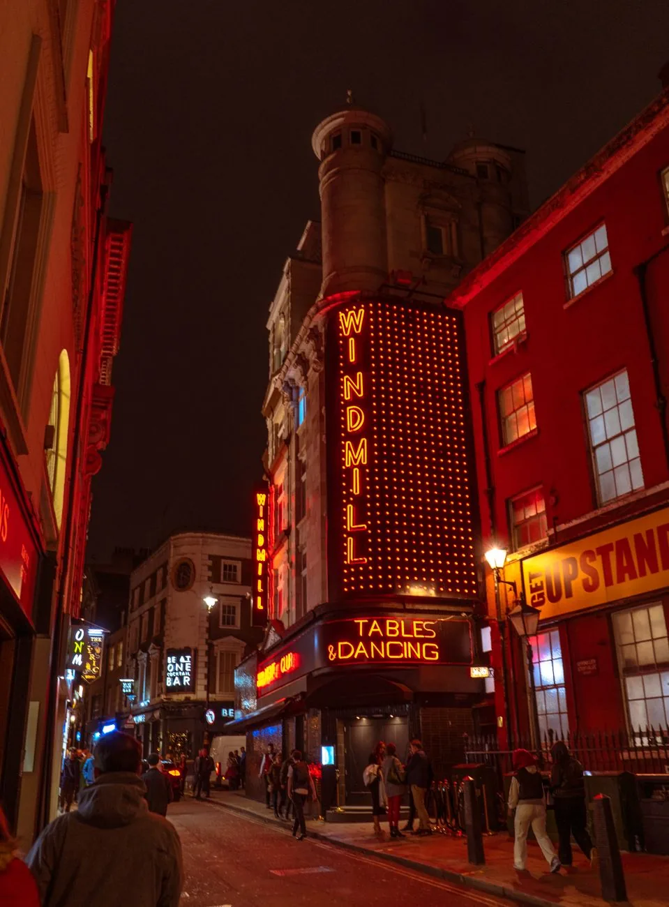 L'enseigne lumineuse du Windmill, dans une rue de Soho le soir