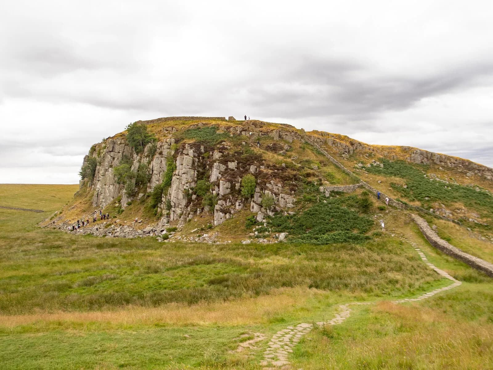 Falaise rocheuse de Steel Rigg, avec le mur d'Hadrien et le sentier qui la longe