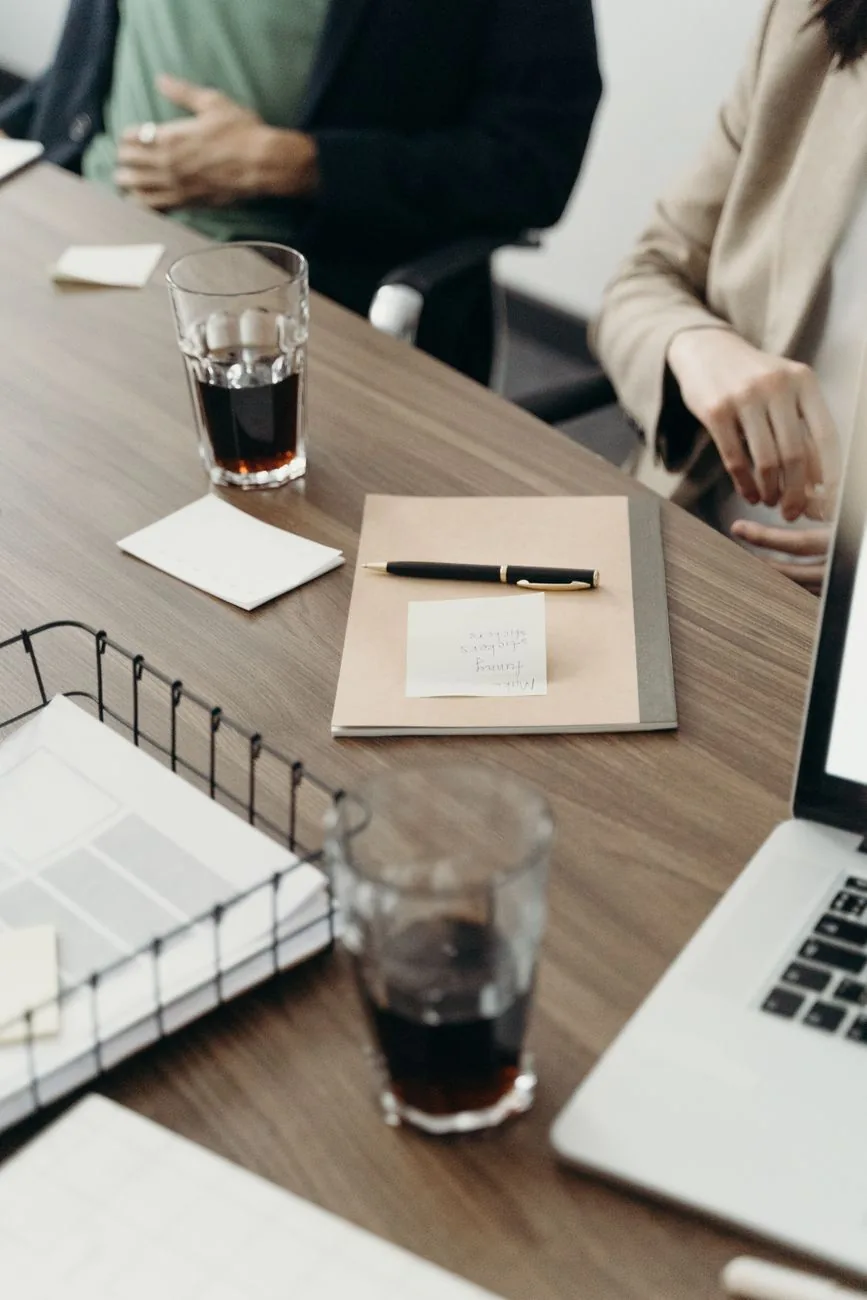 Table de réunion avec dossier, stylo et ordinateur portable