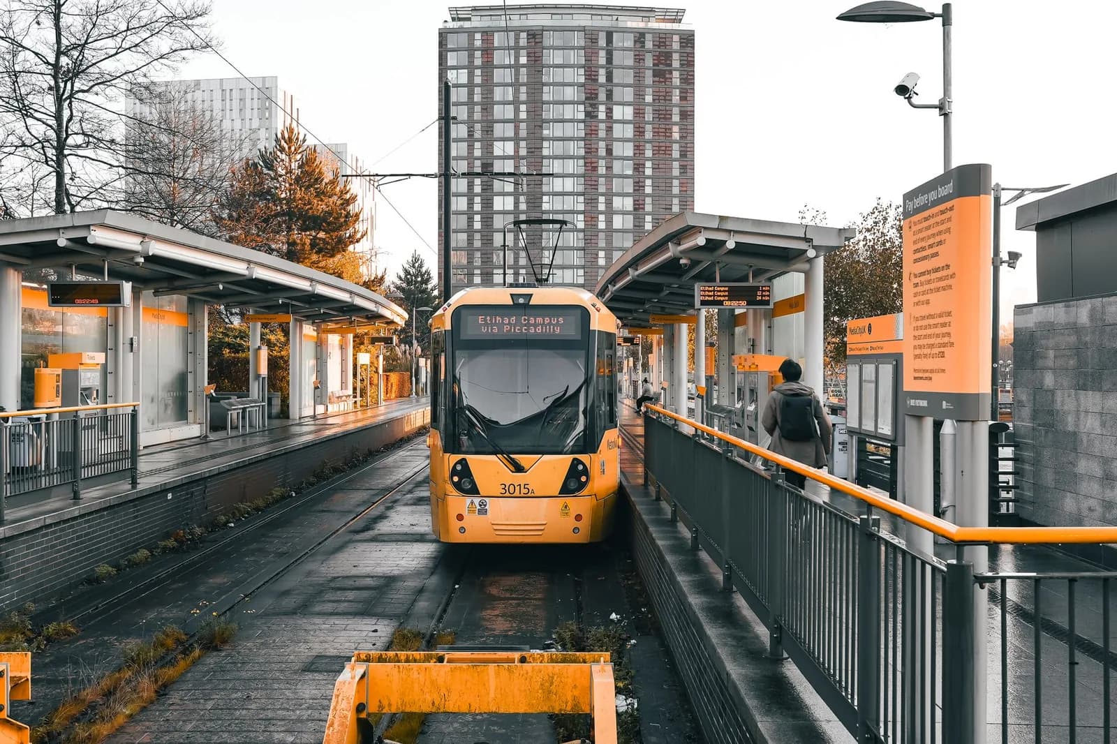 Rame jaune du tramway Metrolink à l'arrêt sur un quai à Manchester