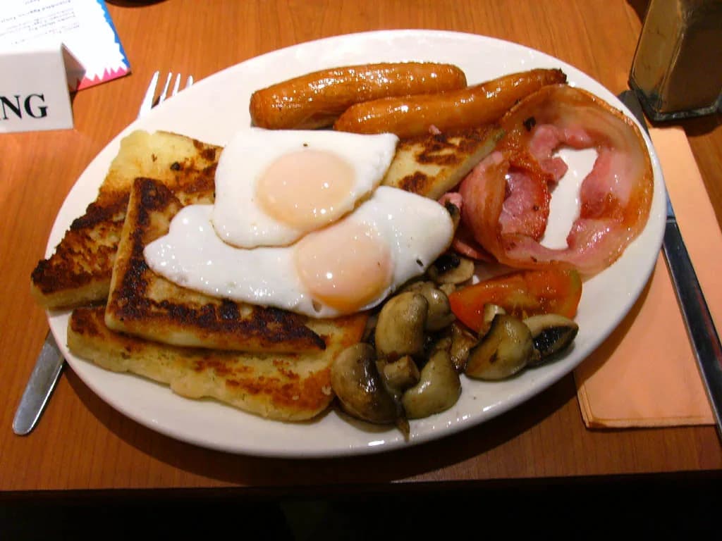 Ulster fry : deux œufs au plat, saucisses, bacon, champignons, tomate, soda farl et potato bread grillés